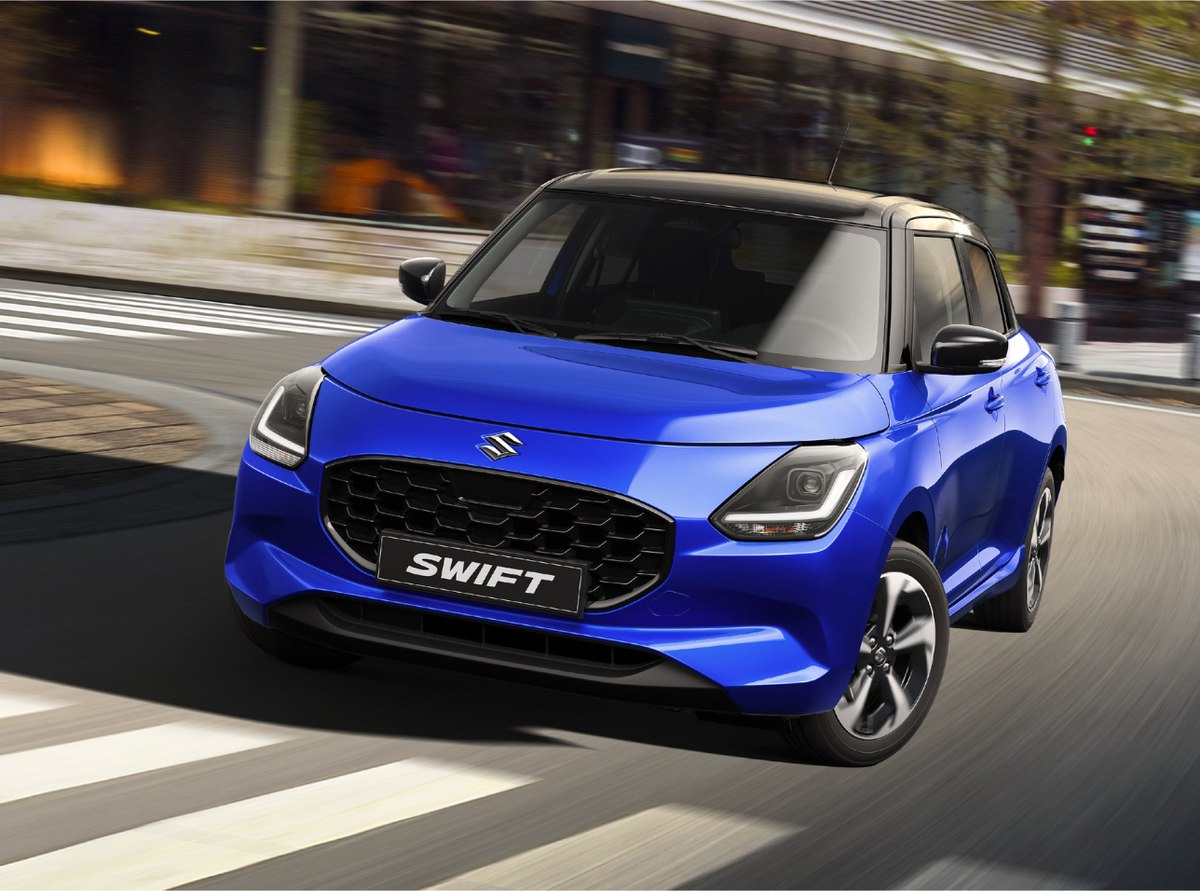 Suzuki Swift màu xanh vận hành trên đường phố