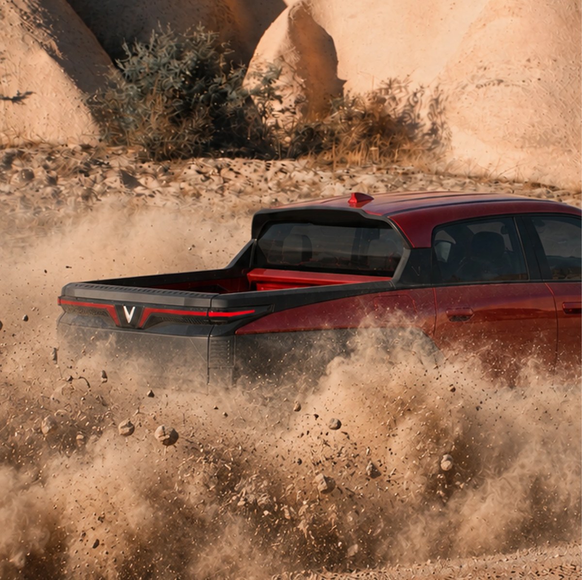 Đuôi xe VinFast VF Wild màu đỏ tung bụi cát khi off-road