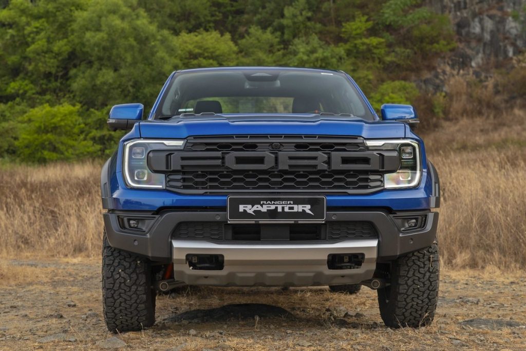 Đầu xe Ford Ranger Raptor màu xanh trên bãi cỏ khô
