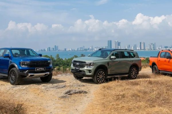 Ranger Raptor màu xanh, Everest màu xanh rêu và Ranger màu cam đỗ trên đồi nhìn ra thành phố ven biển