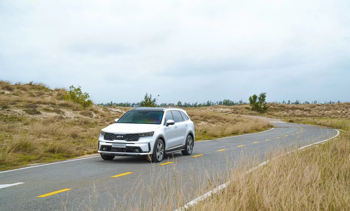Sorento Hybrid màu trắng chạy trên con đường quanh co